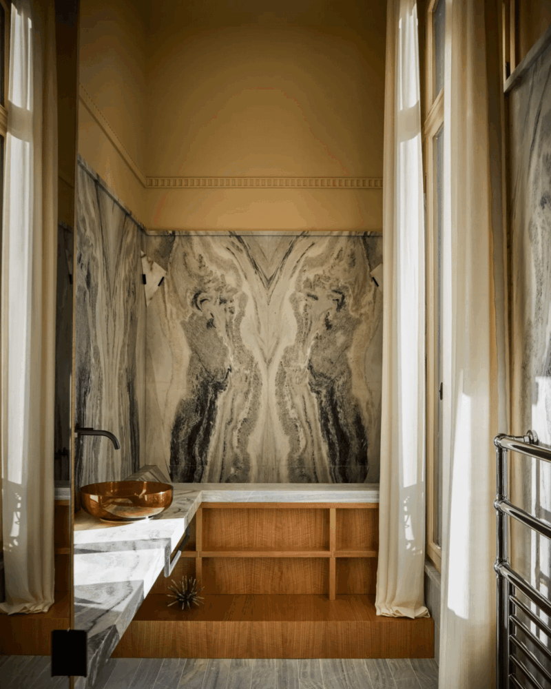 Ancien hôtel particulier repensé en appartement parisien, dans l’esprit des compositions de Pierre Chareau. Dans la salle de bain, une applique d’angle vient habiller le marbre rainuré et souligner la géométrie de l’espace.